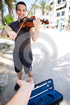 Smiling male busker playing violin photo