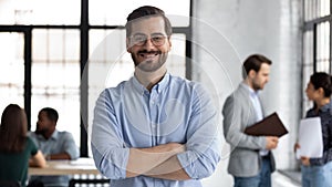 Smiling male CEO posing alone in modern office
