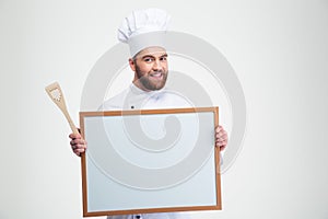 Smiling male chef cook holding blank board