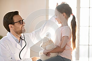 Smiling male doctor cheer small girl child patient