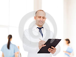 Smiling male doctor with clipboard