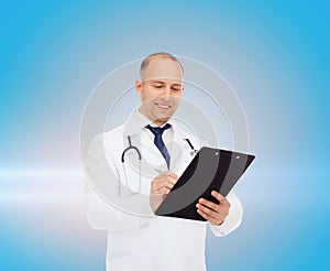 Smiling male doctor with clipboard and stethoscope