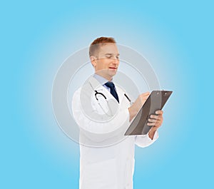 Smiling male doctor with clipboard and stethoscope