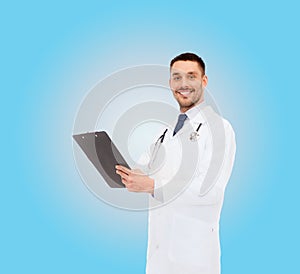 Smiling male doctor with clipboard and stethoscope