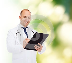 Smiling male doctor with clipboard and stethoscope