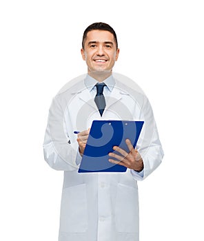 Smiling male doctor with clipboard writing