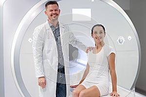 Smiling male doctor and female patient in MRI room closeup