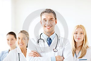 Smiling male doctor in front of medical group