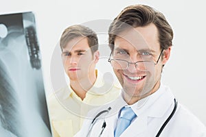 Smiling male doctor and patient examining lungs xray