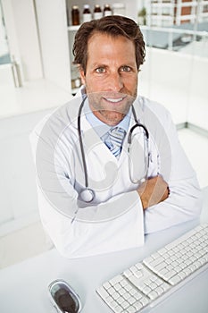 Smiling male doctor sitting at medical office