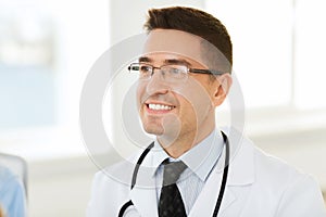 Smiling male doctor in white coat and eyeglasses