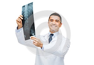 Smiling male doctor in white coat holding x-ray