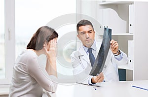 Smiling male doctor in white coat looking at x-ray