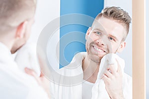 Smiling male drying face photo