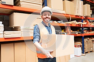 Smiling Male Employee Carrying Box At Warehouse