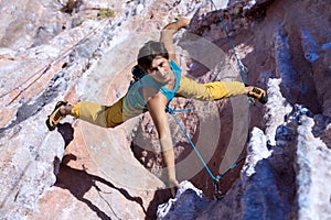 Smiling Male Extreme Climber hanging on unusual shaped Rock