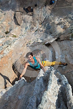 Smiling Male Extreme Climber hanging on unusual shaped Rock