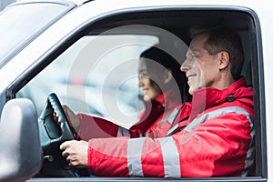 smiling male and female paramedics sitting