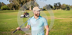 smiling male golf player on professional course with green grass, summer