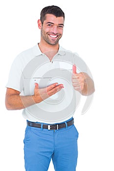 Smiling male handyman with clipboard gesturing thumbs up