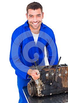 Smiling male machanic repairing car engine