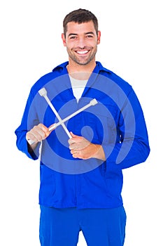 Smiling male mechanic holding lug wrench