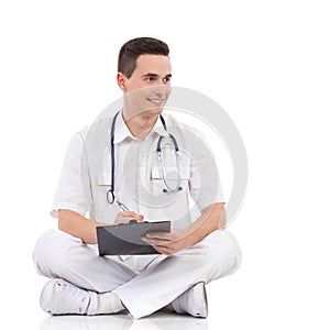 Smiling male medicine student posing with a clipboard