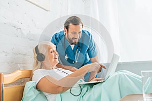 smiling male nurse looking at happy senior woman photo