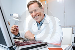 smiling male optician holding lenses for trial frame