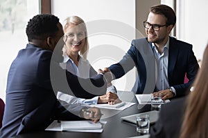 Smiling male partners handshake greeting at office meeting