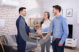 Real Estate Agent Shaking Hands With His Clients