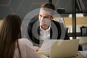 Smiling male recruiter discussing cv with female job applicant