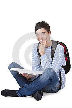 Smiling male student sitting on floor with book