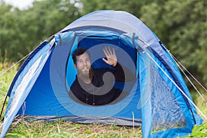 Smiling male tourist with beard in tent