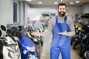 Worker demonstrating motorcycles in workplace