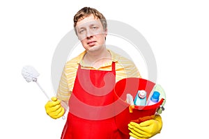 Smiling man in an apron holding a bucket with cleaning agents