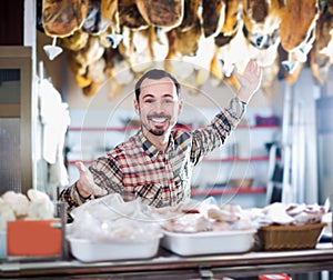 Smiling man assistant showing sorts of meat