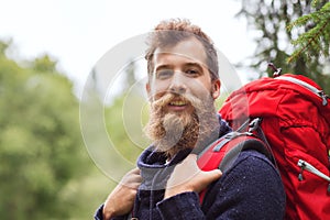 Smiling man with beard and backpack hiking