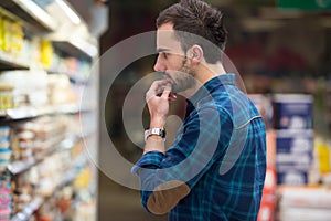 Smiling Man Buying Dairy Products In Supermarket