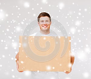Smiling man carrying carton box