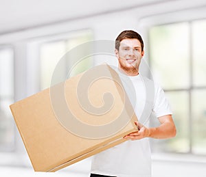 Smiling man carrying carton box