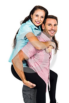 Smiling man carrying his girlfriend on back
