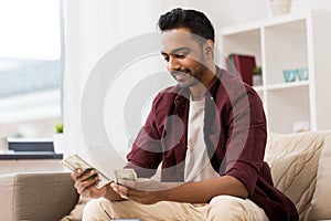 Smiling man counting money at home