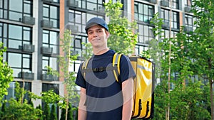 Smiling man courier food delivery with backpack turns head and looks camera