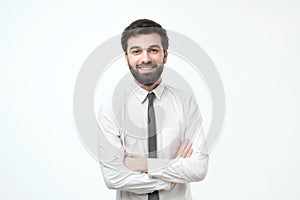 Smiling man with crossed arms over gray background