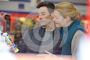 Smiling man customer buying sealing component in household shop