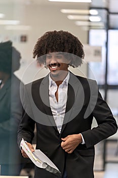 Smiling man with documents in a business setting.
