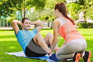 Smiling man doing exercises on mat outdoors