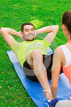 Smiling man doing exercises on mat outdoors
