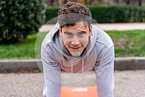 Smiling man doing plank in park